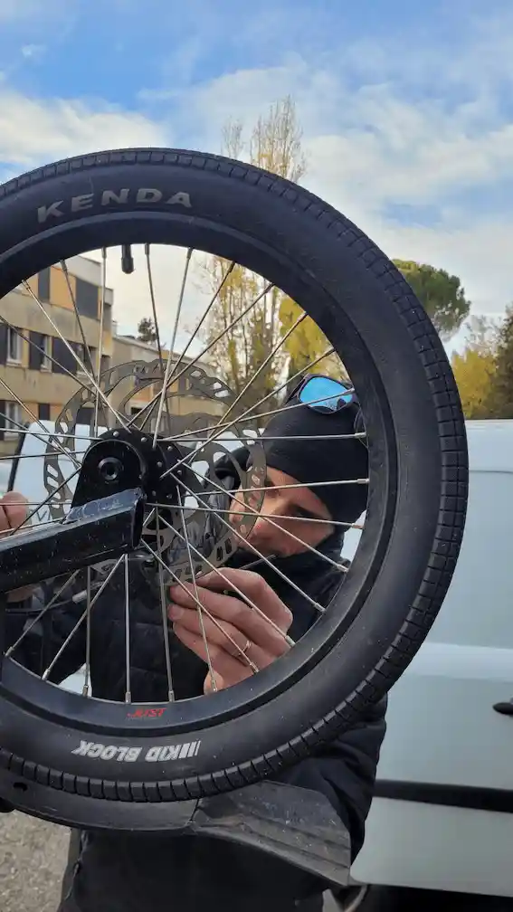 Le mécanicien Doc Bike Service ajustant une roue avec frein à disque